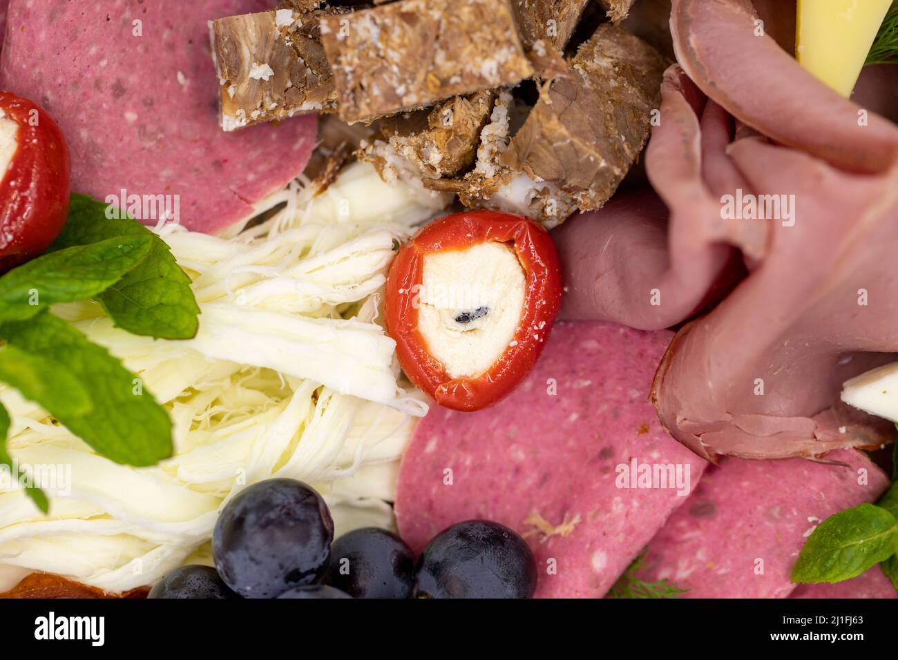 Kalte geräucherte Fleischplatte, Antipasto-Set Platte Holzplatte. Antipasto-Tafel mit geschnittenem Fleisch, Schinken, Salami, Käse. Nahaufnahme Stockfoto