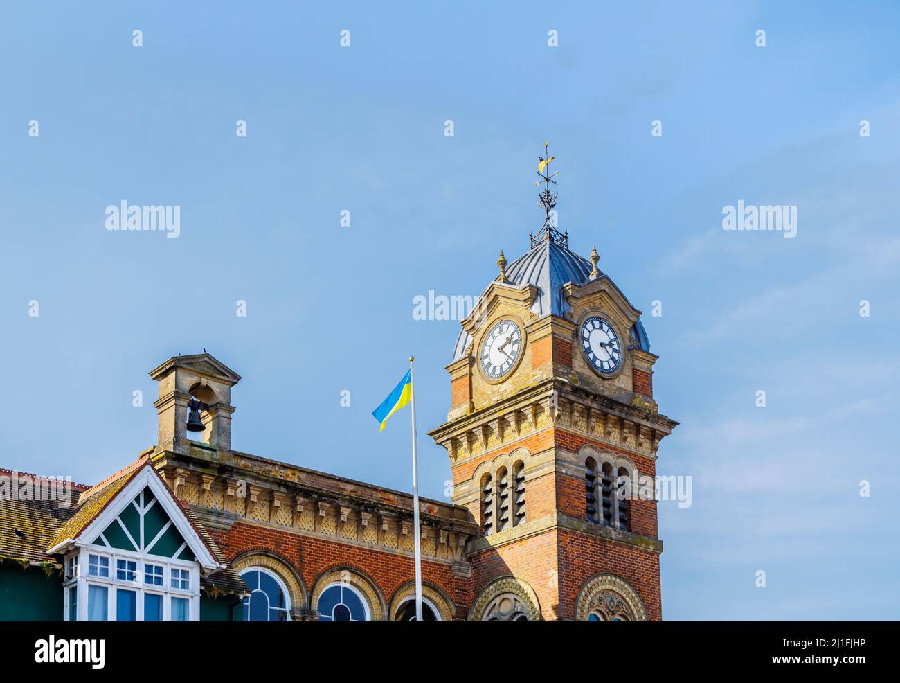 Der Uhrenturm des Wahrzeichen Town Hall council Offices in Hungerford, einer Stadt in berkshire, mit der ukrainischen Nationalflagge zur Unterstützung der Ukraine Stockfoto