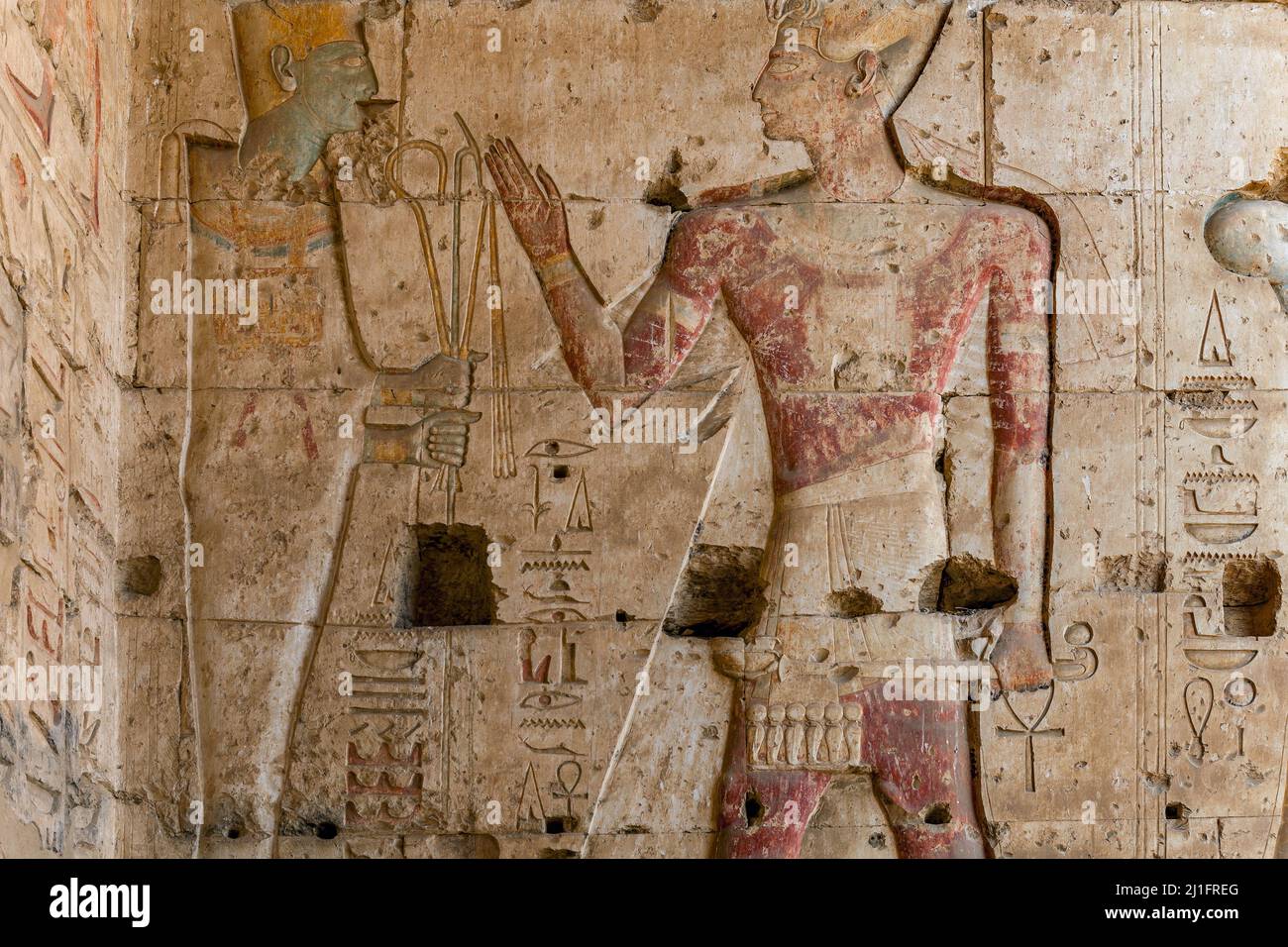 Wandschnitzerei zeigt den gott Osiris, der König Seti I im Großen Tempel von Abydos, Ägypten, den Gauner und Faulpelz anbietet Stockfoto