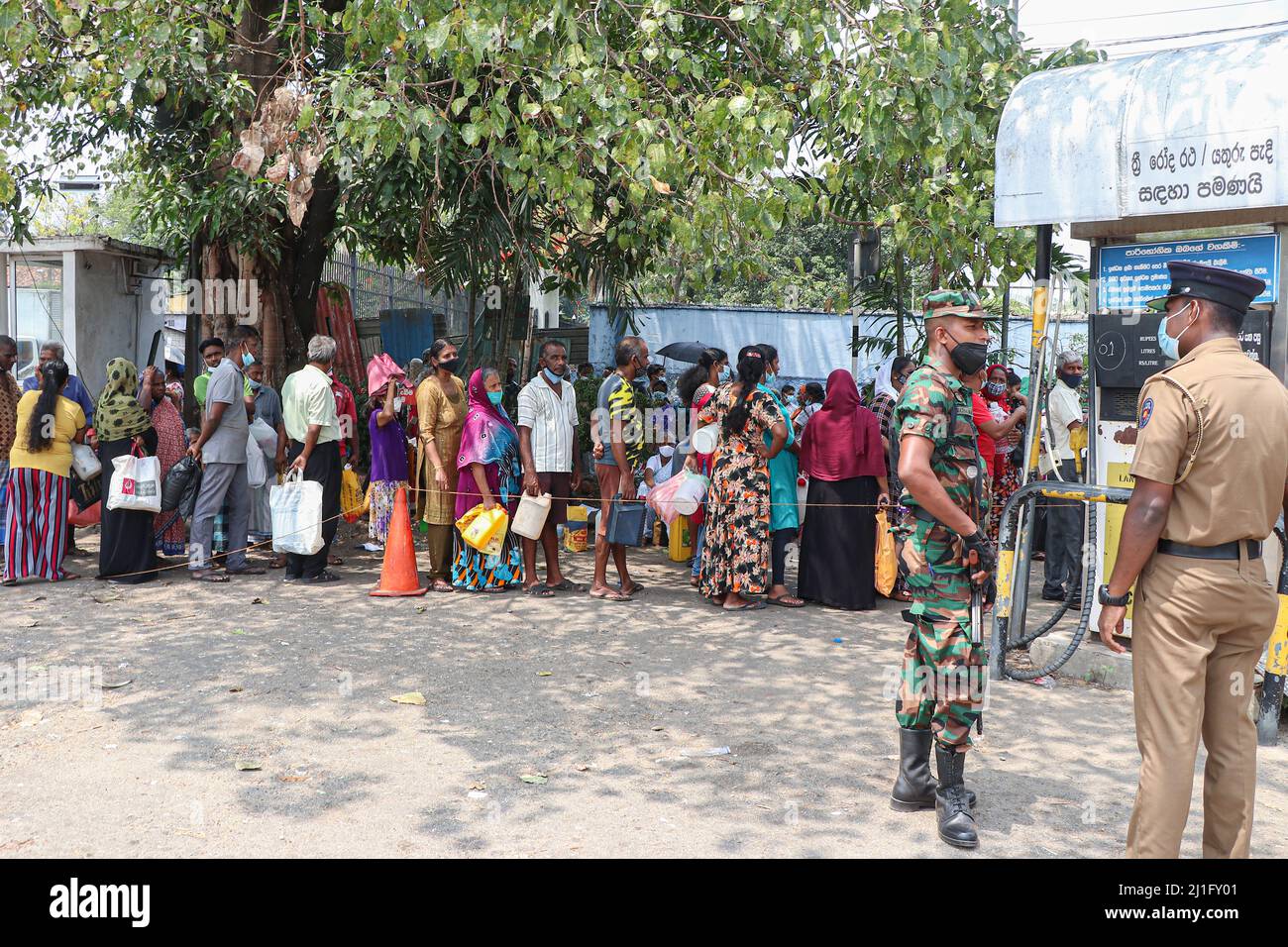 Ein Soldat der srilankischen Armee bewacht am 24. März 2022 in Colombo, Sri Lanka, eine Tankstelle, während Menschen darauf warten, Kraftstoff zu bekommen. (Foto von Saman Abesiriwardana/Pacific Press/Sipa USA) Stockfoto