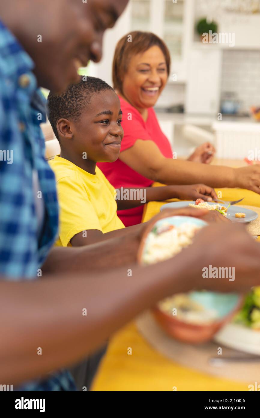 Lächelnder afroamerikanischer Junge, der am Danktag mit der Familie zu Hause zu Mittag gegessen hat Stockfoto