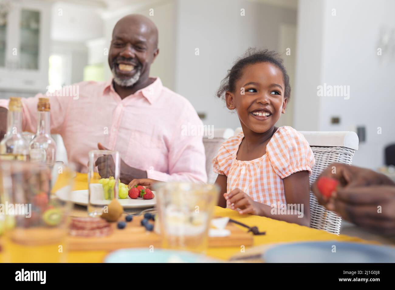 Glückliches afroamerikanisches Mädchen, das am Danktag mit der Familie zu Hause zu Mittag gegessen hat Stockfoto