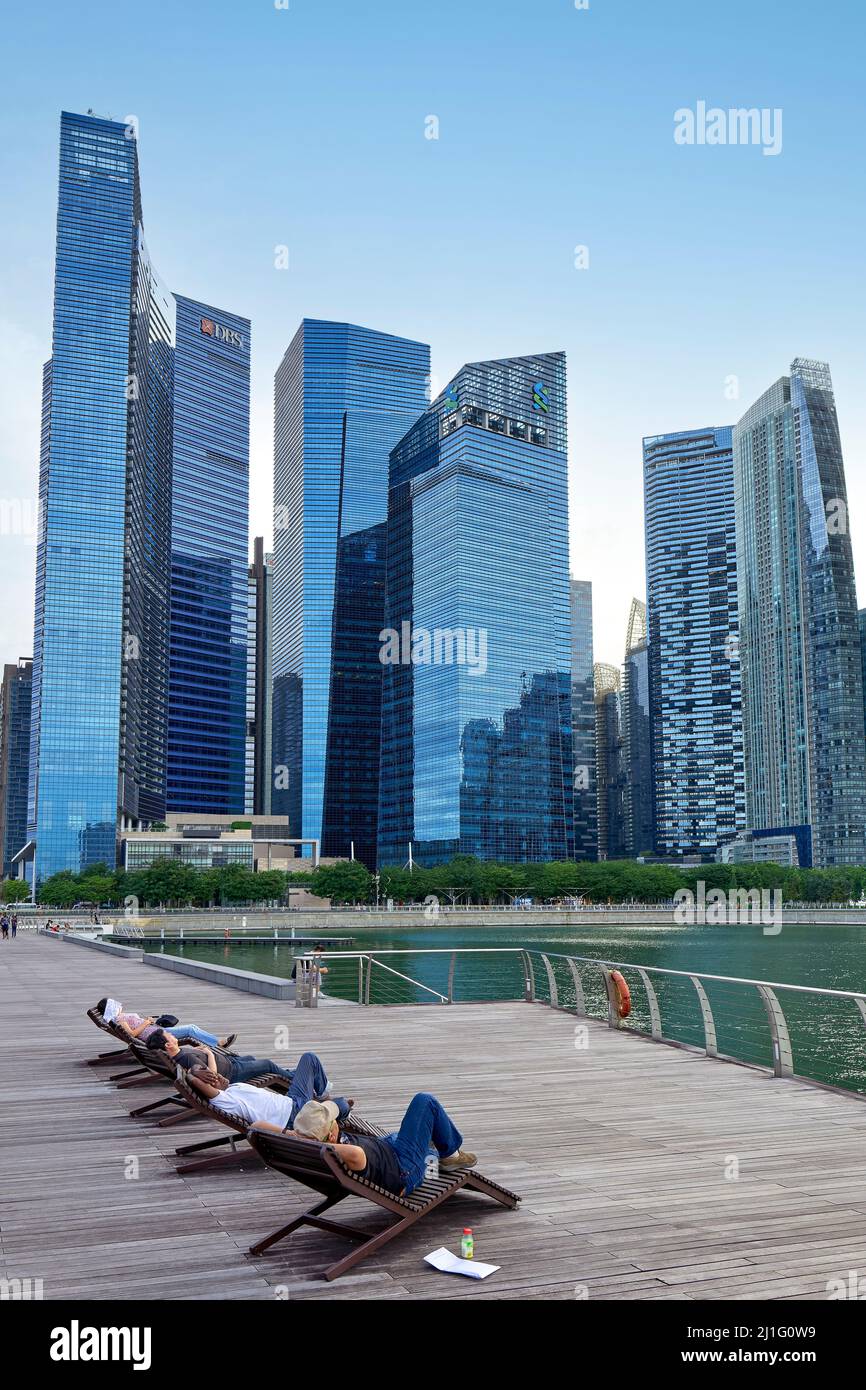 Singapur. Marina Bay. Menschen, die sich vor dem Finanzdistrikt entspannen Stockfoto