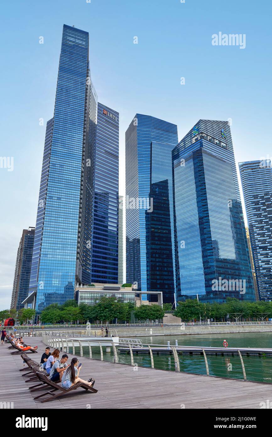 Singapur. Marina Bay. Menschen, die sich vor dem Finanzdistrikt entspannen Stockfoto