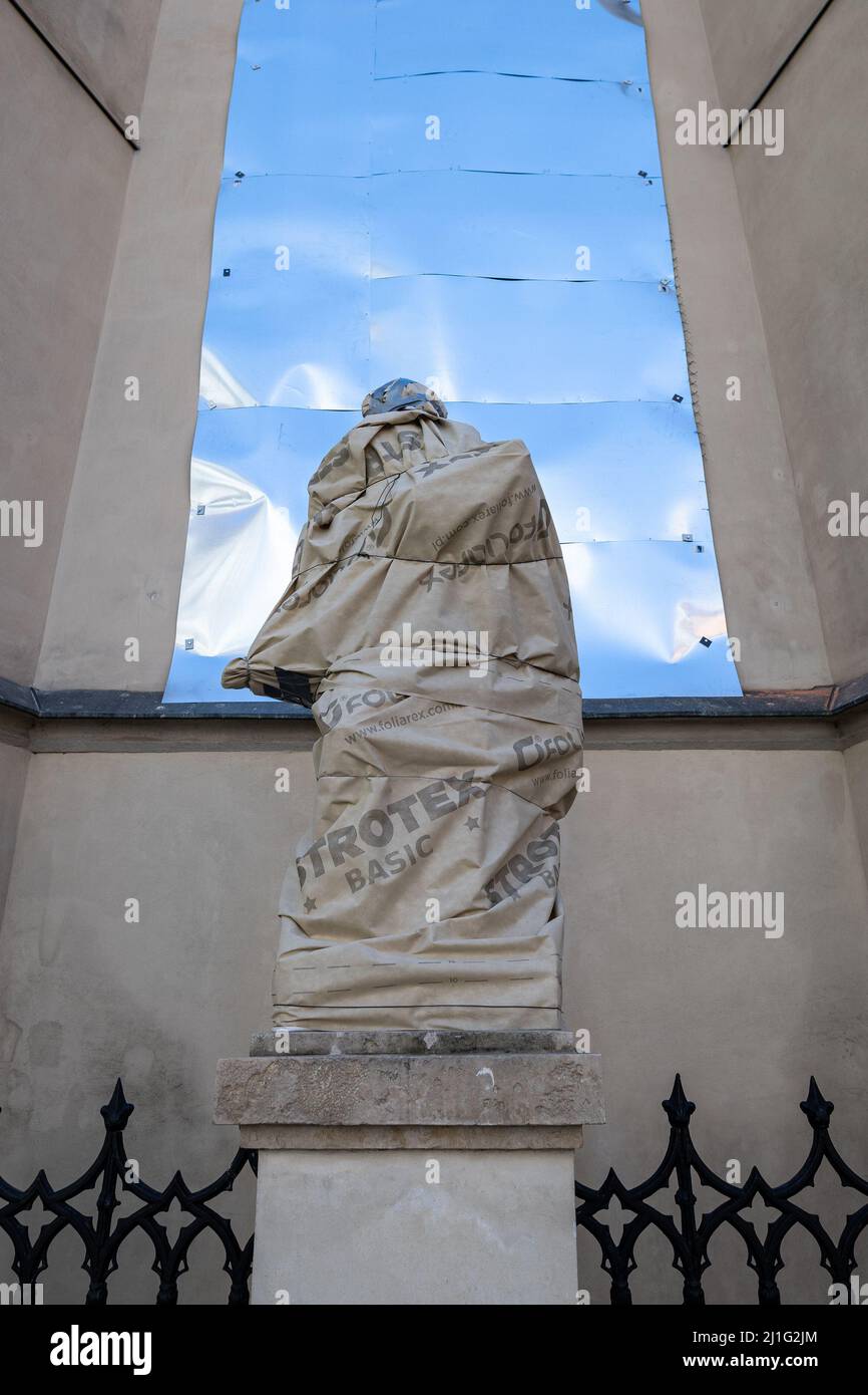 LVIV, UKRAINE - 20. März 2022:um sie vor Schäden zu schützen, werden Skulpturen der Heiligen der lateinischen Kathedrale eingewickelt und Glasmalerei mit glasmalerei Stockfoto