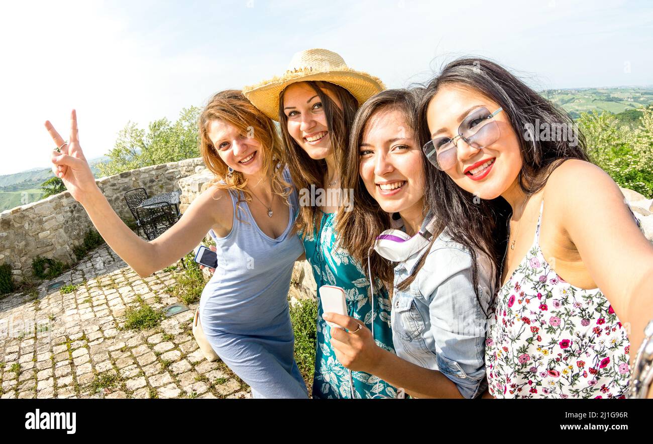 Vier multirassische Millennial-Freundinnen, die Selfie auf einem Landausflug machen - glückliche Mädchen, die Spaß in den Straßen der Altstadt haben - Universitätsfrauen st Stockfoto