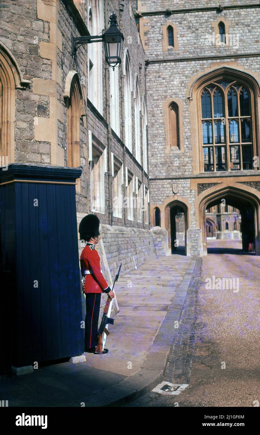 1960s, historisch, Grenadier Wache vor seinem Wachkasten in der historischen königlichen Residenz von Windsor Castle, Berkshire, England, Großbritannien. Ein Wachmann wird zwei Stunden lang im Wachdienst sein. Eine Reihe von verschiedenen Infanterieregimenten stellen die Wachen auf der Burg, sowie zwei Regimenter der Kavallerie im Haushalt zur Verfügung. Stockfoto