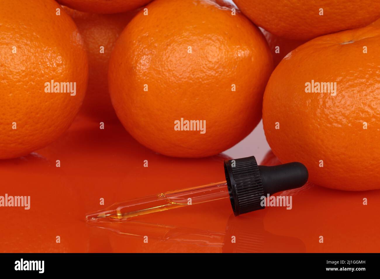 Tropferfarbe mit orangefarbenem Hintergrund, Massageöl. Die entspannenden Eigenschaften der Natur. Stockfoto