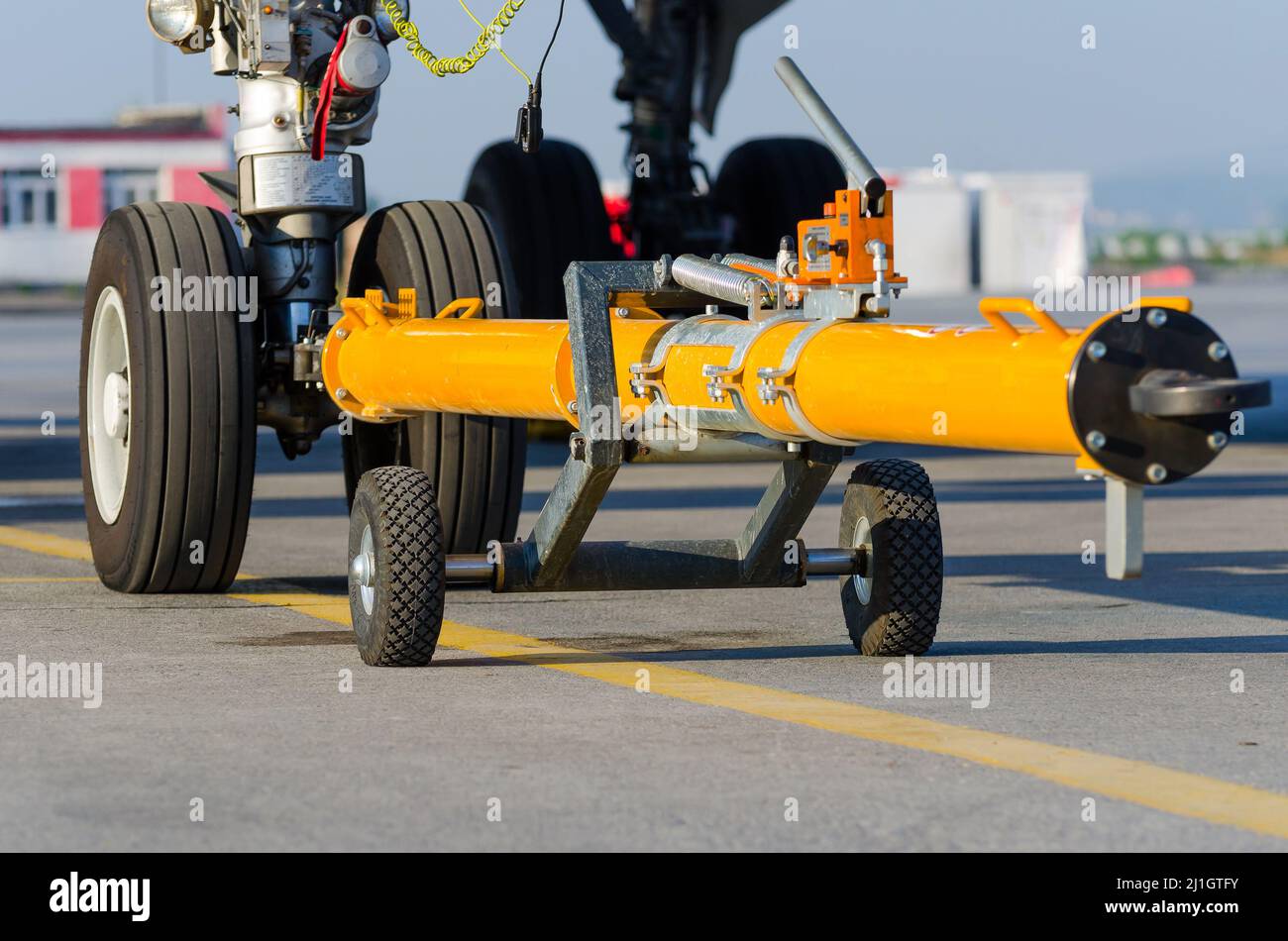 Schieben Sie das Flugzeug auf dem vorderen Fahrwerk des Chassis zurück auf den Wagen. Stockfoto