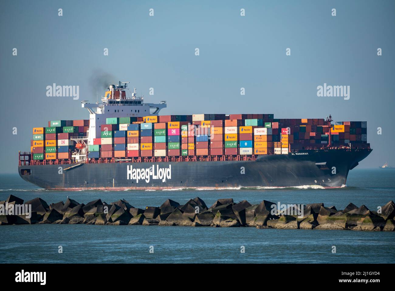 Das Containerschiff Al Manamah, im Besitz von Hapag-Lloyd, befindet sich am Hafeneingang des Tiefseehafens Maasvlakte 2, dem Seehafen von Rotterdam, Niederlande Stockfoto