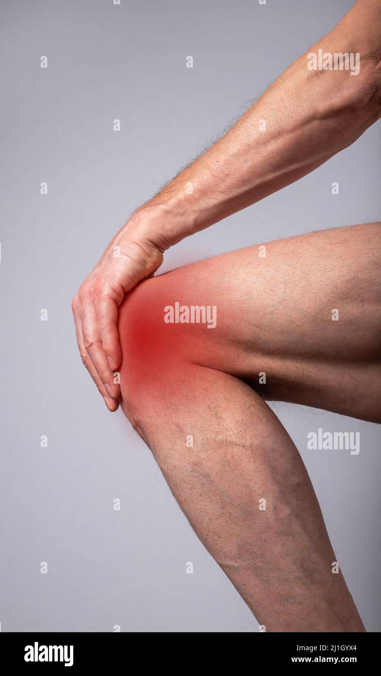Knieschmerzen. Die Hand des Mannes berührt das Bein mit einer roten Nahaufnahme. Gelenkverletzungen, Bänder und Sehnen dehnen sich aus. Krankheiten, Gesundheitsprobleme, Behandlungskonzept. Hochwertige Fotos Stockfoto