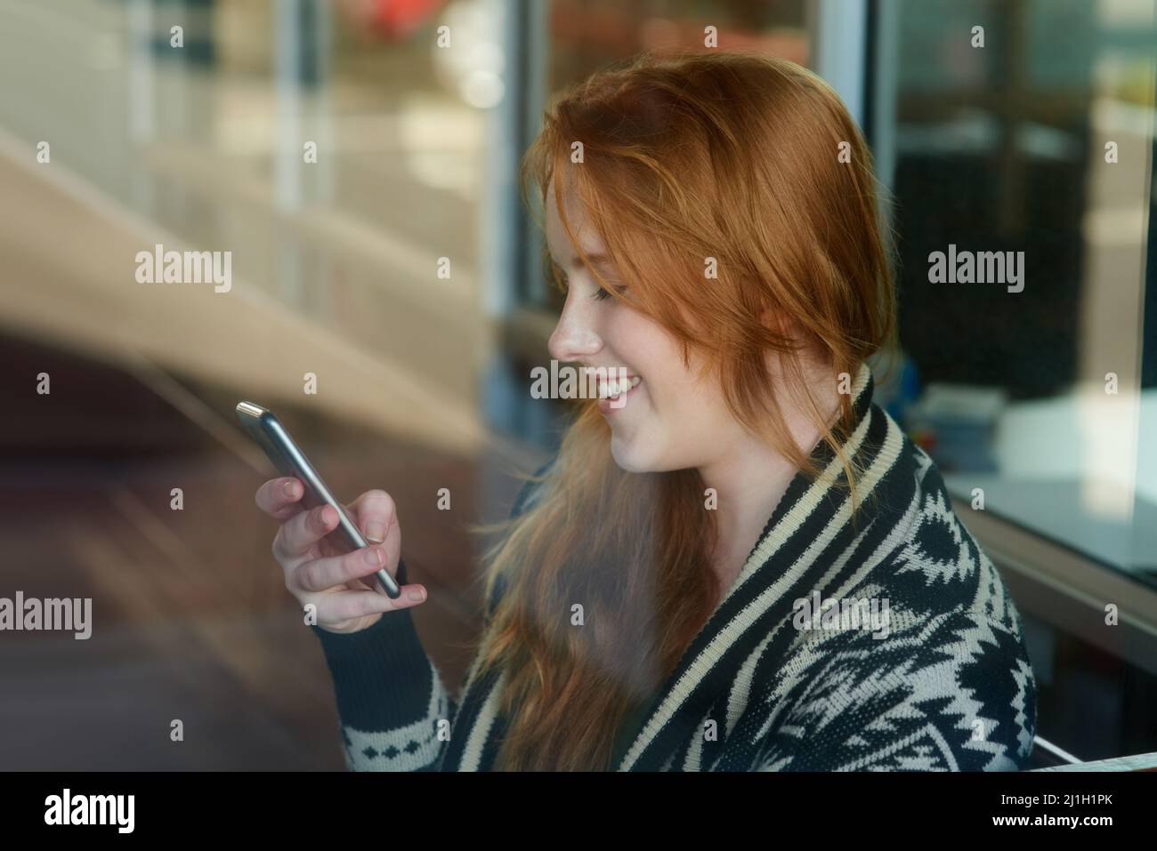 Treffen wir uns nach dem Unterricht. Ausgeschnittene Aufnahme einer Universitätsstudentin, die auf ihrem Handy auf dem Campus SMS schreibt. Stockfoto