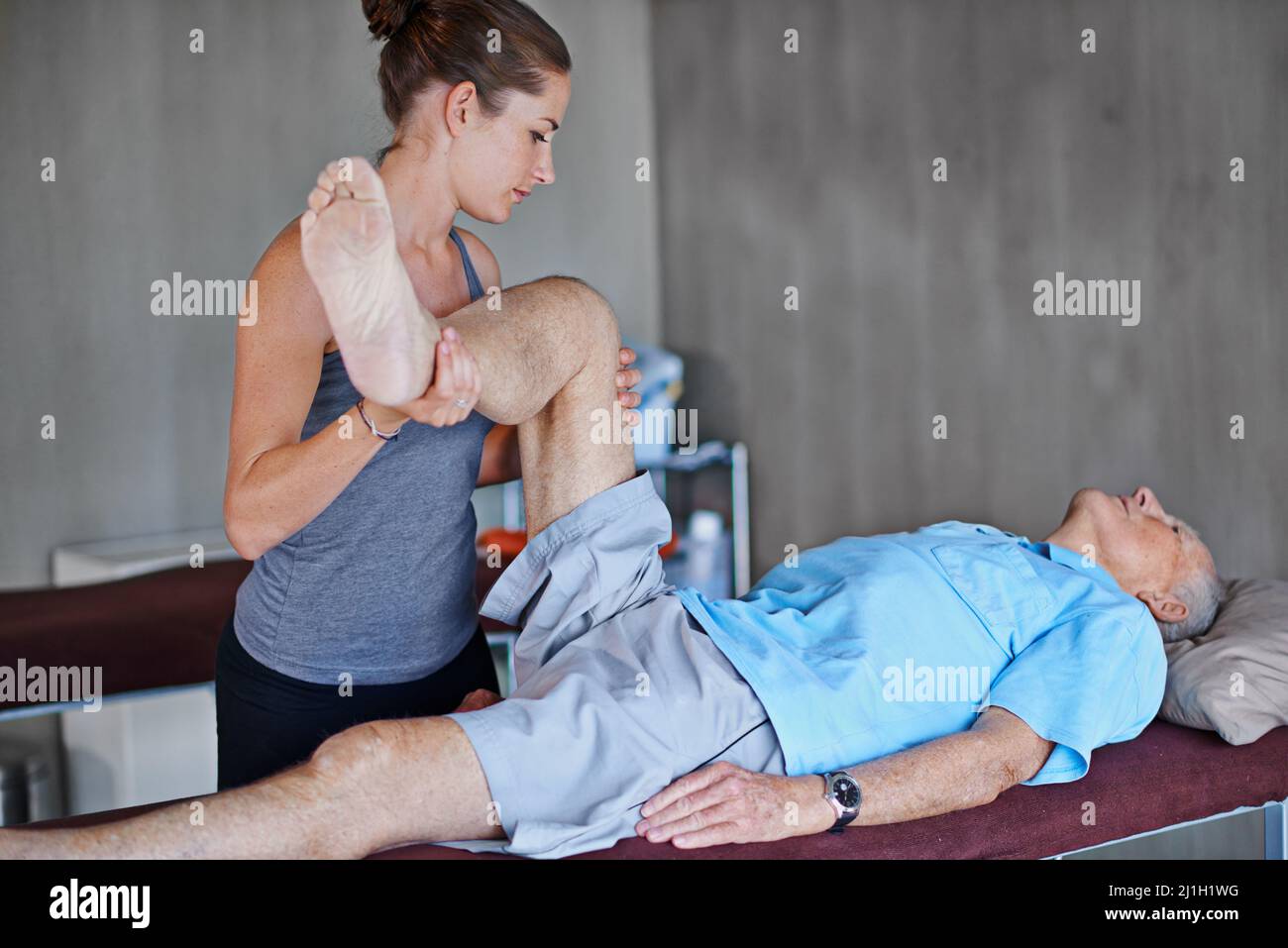 Versuchen Sie, diese Position so lange wie möglich zu halten. Aufnahme eines älteren Mannes, der eine Physiotherapie-Sitzung hatte. Stockfoto
