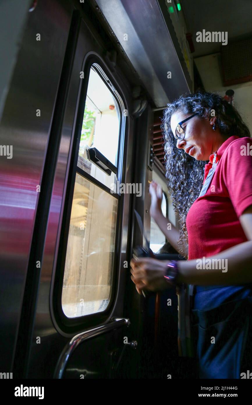 San Jose, Costa Rica - Menschen in der Kutschenbahn, die in die Stadt fährt. Frau, die aus dem offenen Fenster schaut. Tägliches Leben des Pendlers im Zug. Stockfoto