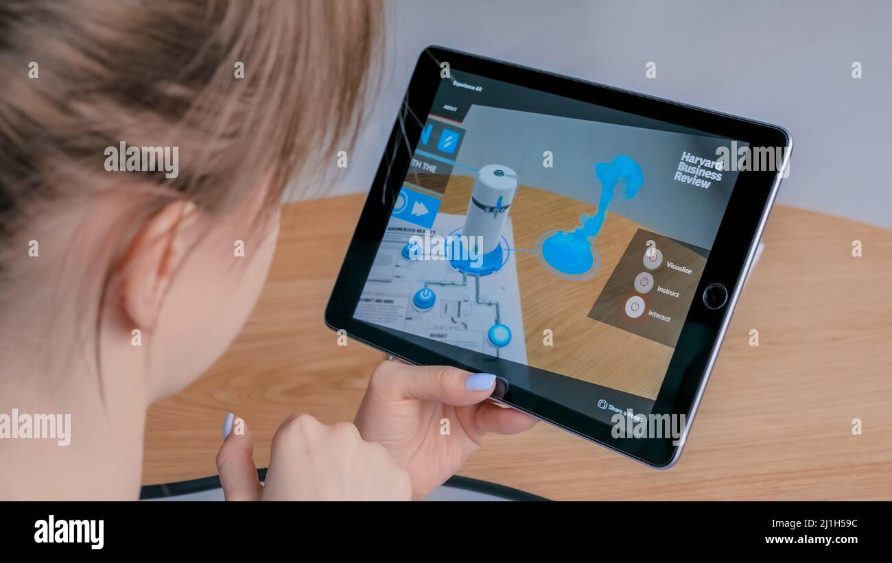 Frau, die ein Tablet mit Augmented Reality App nutzt – robotisierte Produktionsmodule Stockfoto