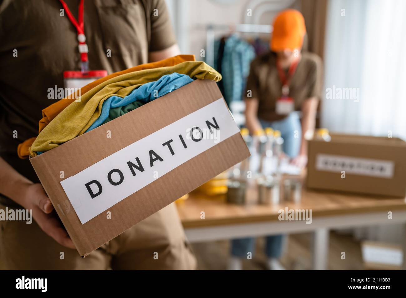 Nahaufnahme der Hände eines unbekannten Freiwilligen, der an der Stiftung arbeitet, mit Kleidung und Sachen für die Spende, kopieren Raum humanitärer A Stockfoto