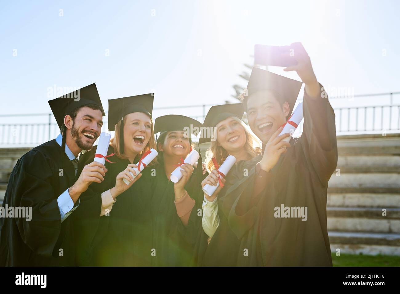 Es ist einer der hellsten Momente, die sie gemeinsam erleben werden. Aufnahme einer Gruppe von Studenten, die am Abschlusstag ein Selfie zusammen machen. Stockfoto