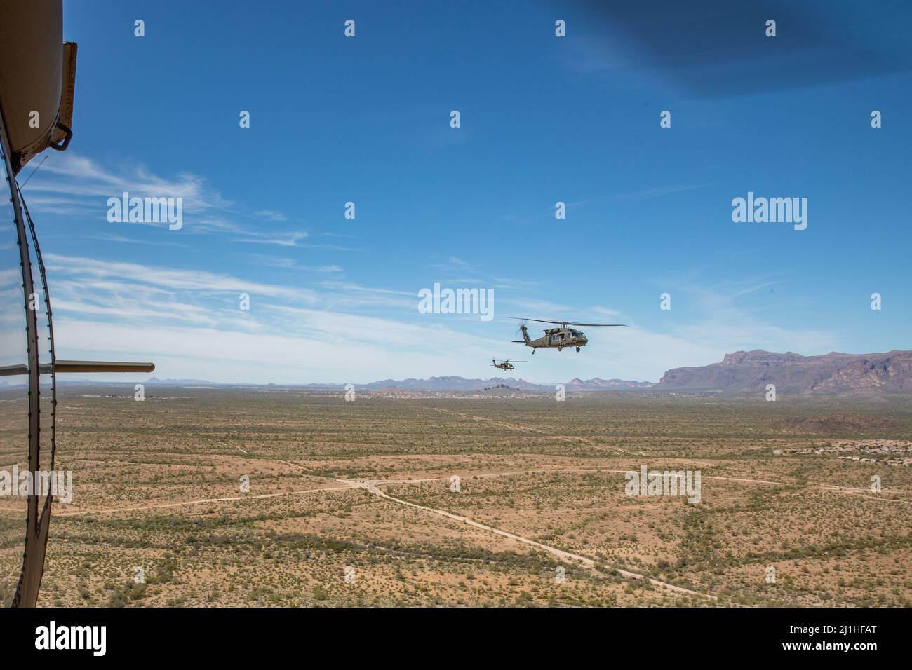 Zwei Hubschrauber der Serie UH-60 Black Hawk bringen die Teilnehmer der Best Warrior-Serie durch die Wüste von Arizona nach Florenz, Arizona, 22. März 2022. Soldaten, die an diesem Event teilnehmen, haben die einmalige Gelegenheit, jedes erworbene Fachwissen in ihre Heimateinheiten zurückzubringen und die Bereitschaft der Arizona National Guard (USA) insgesamt zu verbessern Foto der Armee-Nationalgarde von Sgt. Jacob Dunlap, Freigelassen). Stockfoto