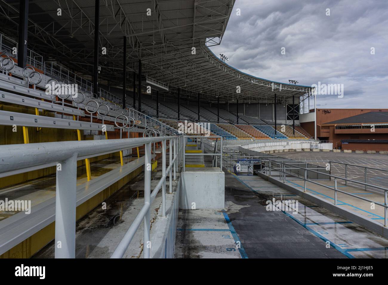 Offene Stadionsitze, die in den Farben Blau, Orange und Grau sehr gut aussehen. Stockfoto