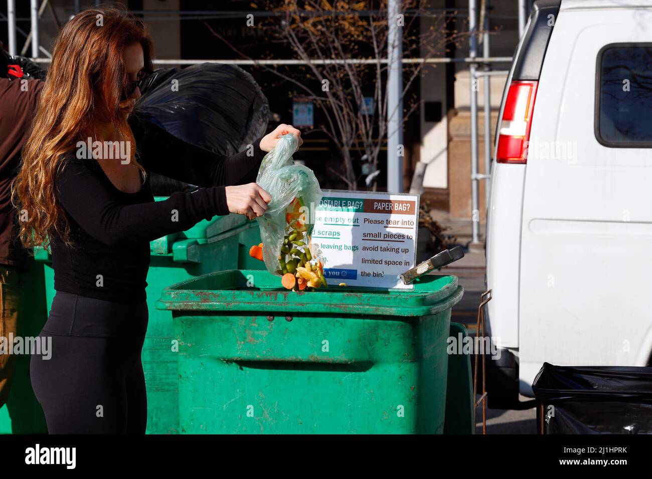 Eine Frau leert Lebensmittelreste in einen Kompostbehälter am Union Square Greenmarket, New York. Die Lebensmittelabfälle an diesem Standort werden von Les Ecology gesammelt Stockfoto