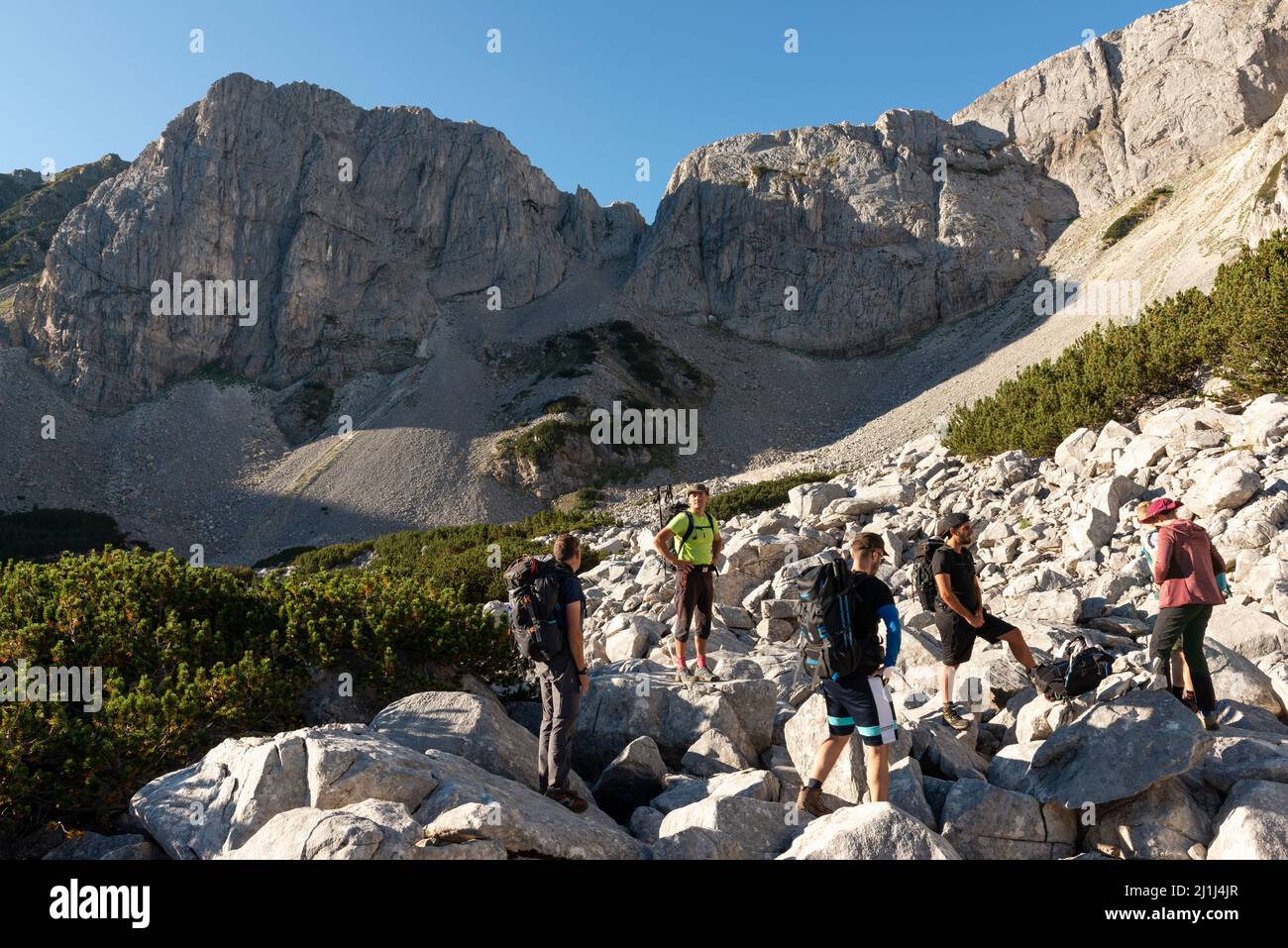 Wandergruppe, die auf Felsbrocken am Fuße des Sinanitsa-Marmors im Pirin-Nationalpark und -Reservat, Bulgarien, Balkan, Europa, steht Stockfoto