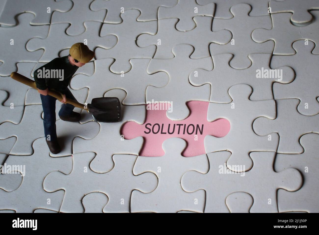 Miniatur-Mann und fehlende Puzzle mit Text-LÖSUNG. Suche nach Lösungskonzept. Stockfoto