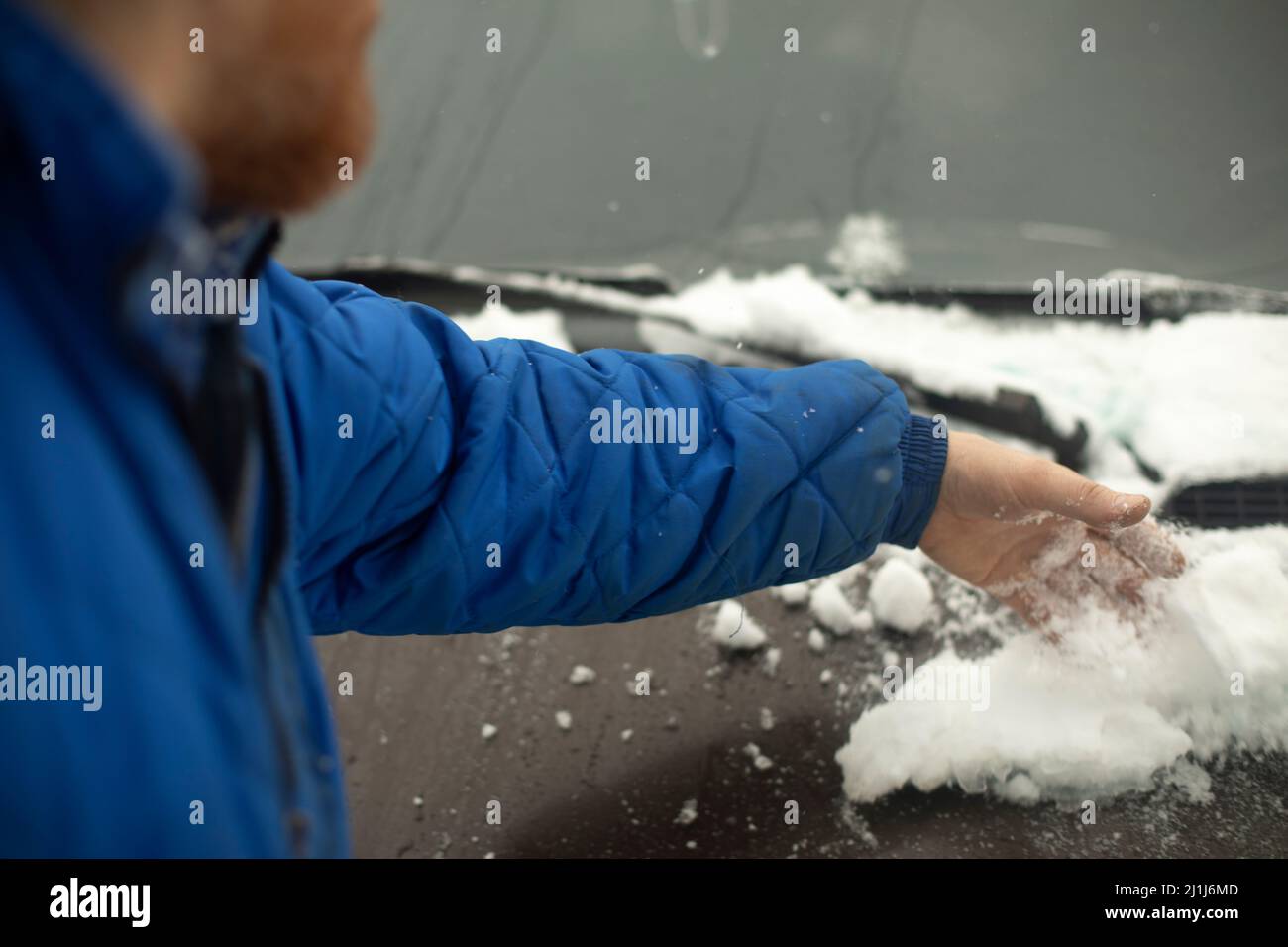 Schneeräumung aus dem Auto. Die Hand kratzt Eis vom Auto. Der Mensch  entfernt Schnee Stockfotografie - Alamy