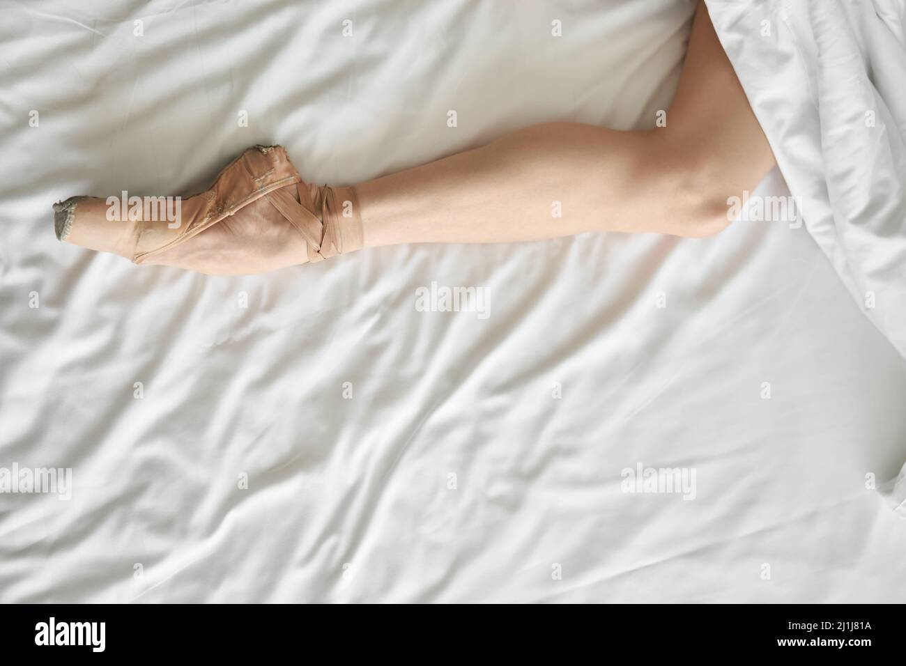 Die Frau im spitzenschuh zeigt ihr Bein aus dem Deckchen Stockfoto