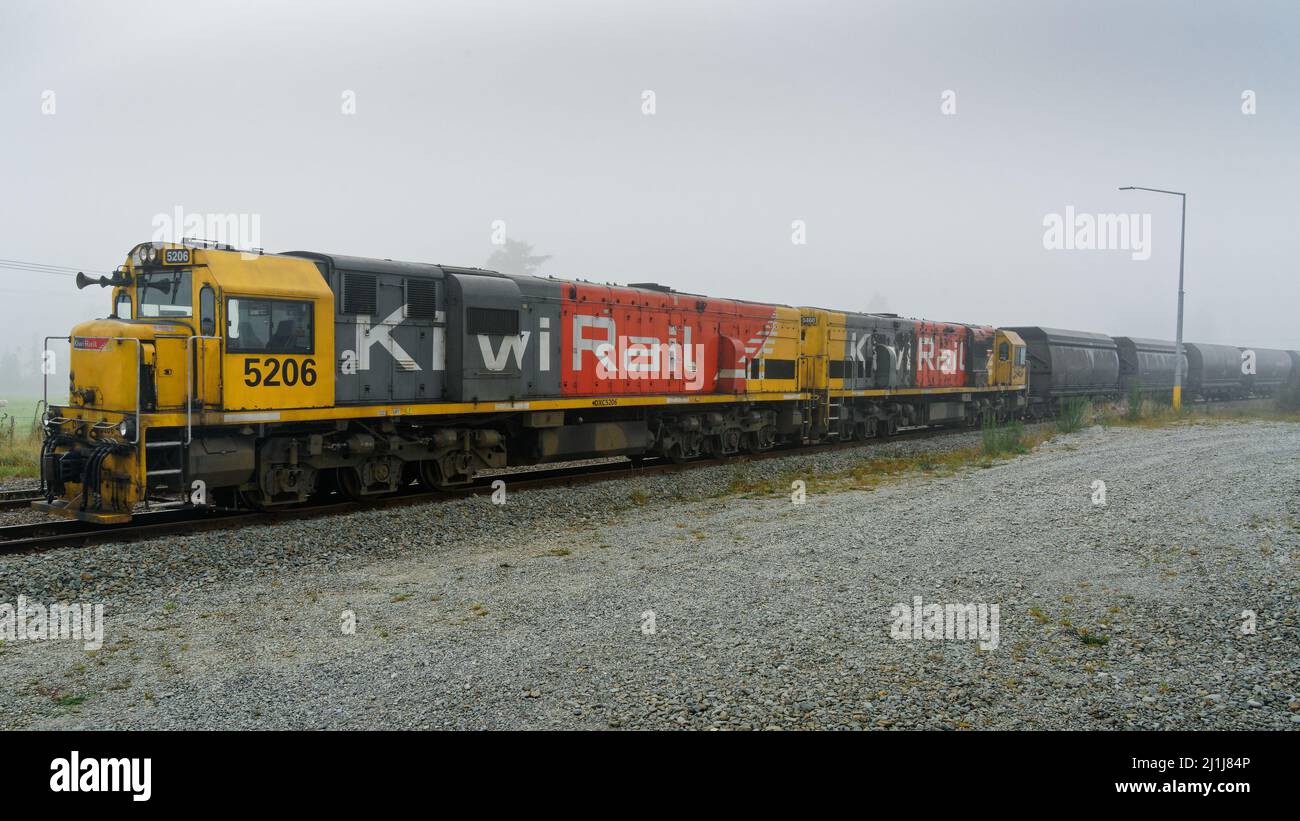 Arthur's Pass/Neuseeland, 5. März 2022: Zwei Lokomotiven der Kiwi Rail ziehen einen langen Zug von kohlebeförderten Schienenfahrzeugen im Arthur's Pass. Stockfoto