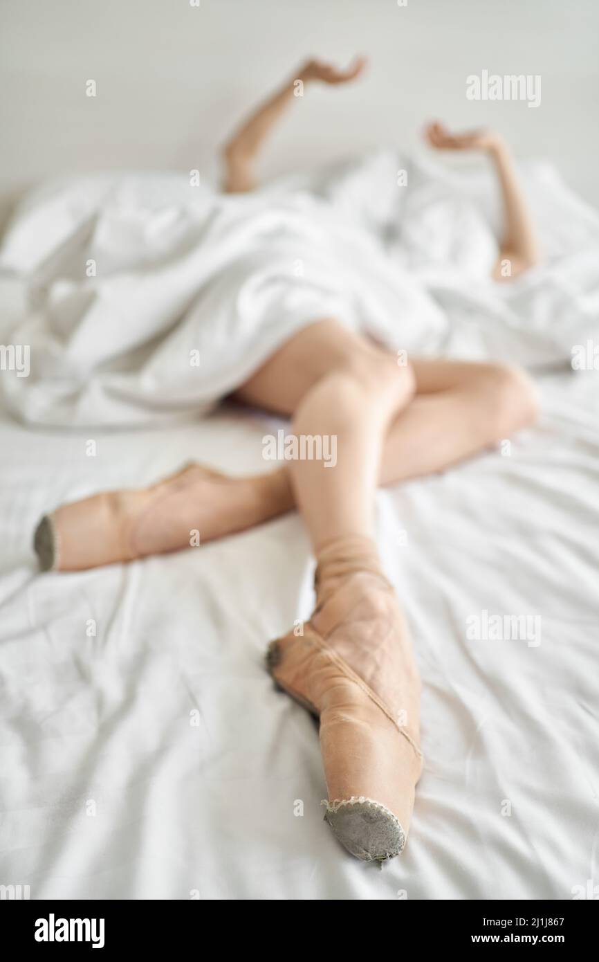 Frau in Spitzenschuhen zeigt ihre Beine und Arme unter dem Deckelchen Stockfoto