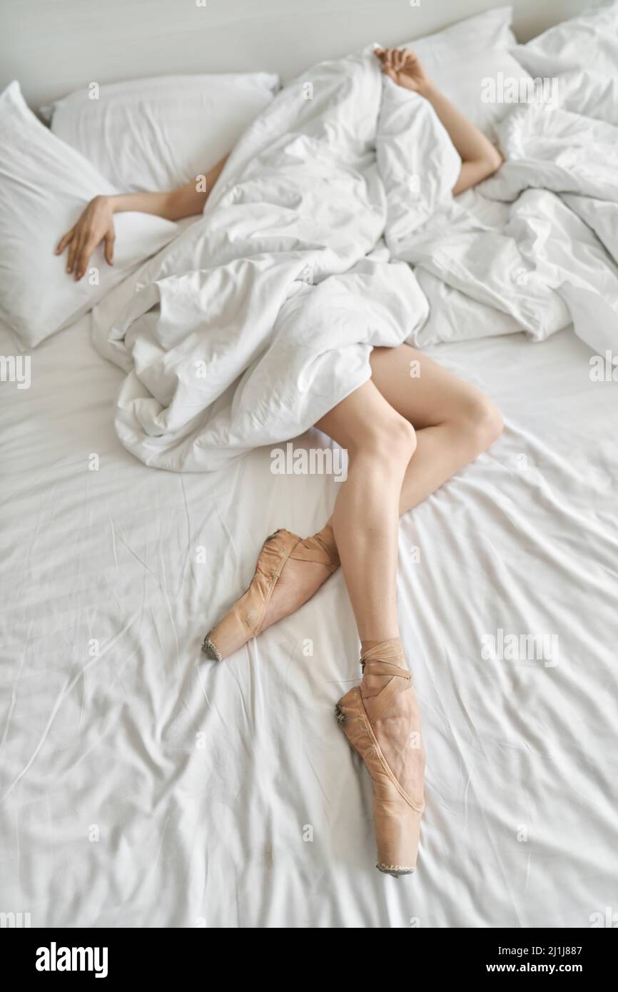 Frau in Spitzenschuhen zeigt ihre Beine und Arme unter dem Deckelchen Stockfoto