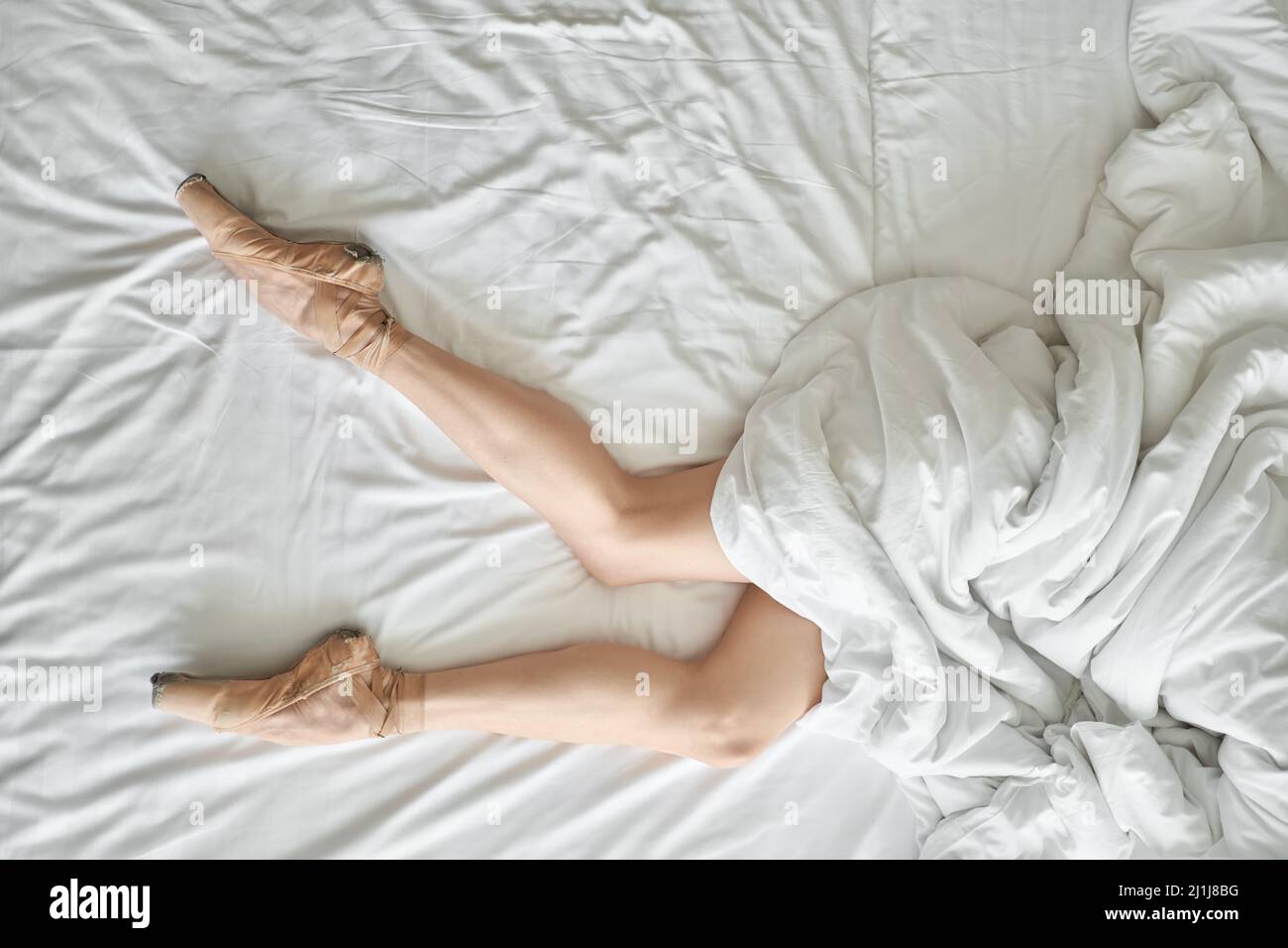 Frau in Spitzenschuhen zeigt ihre Beine unter dem Deckchen Stockfoto