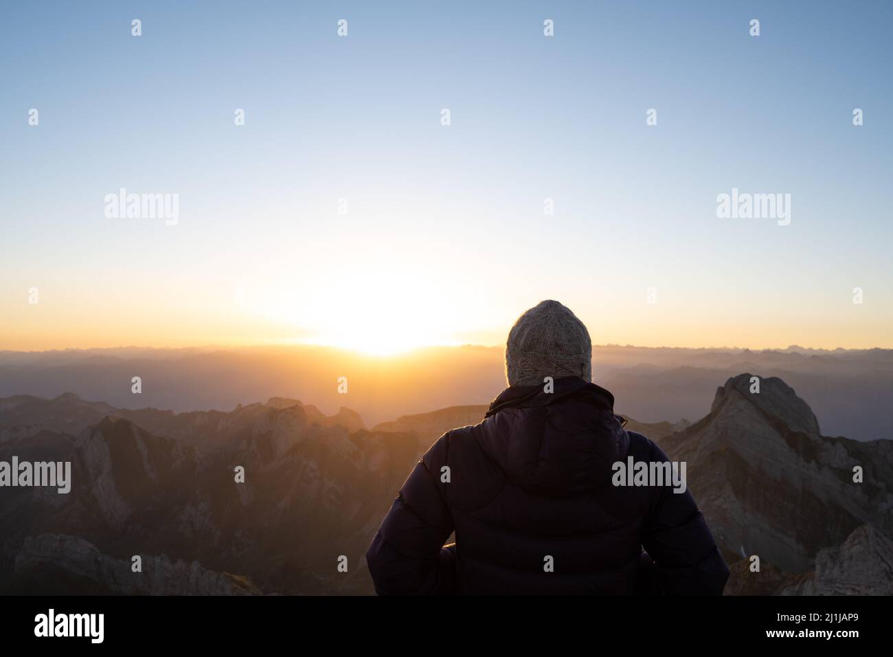 Frau, die den Sonnenaufgang auf dem Berg genießt Stockfoto