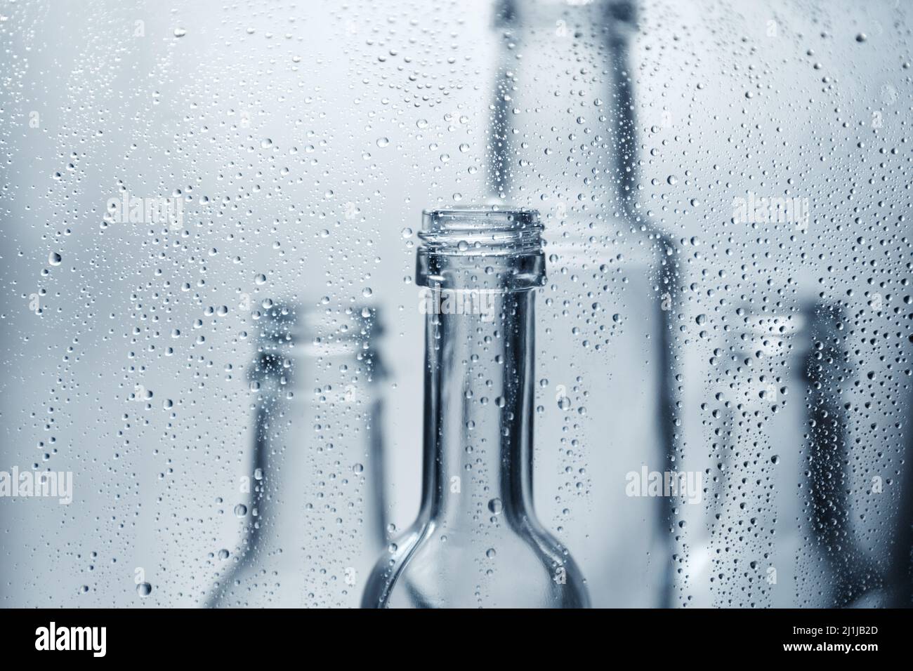 Transparente Glasflaschen in Wassertropfen. Glasteller. Stockfoto