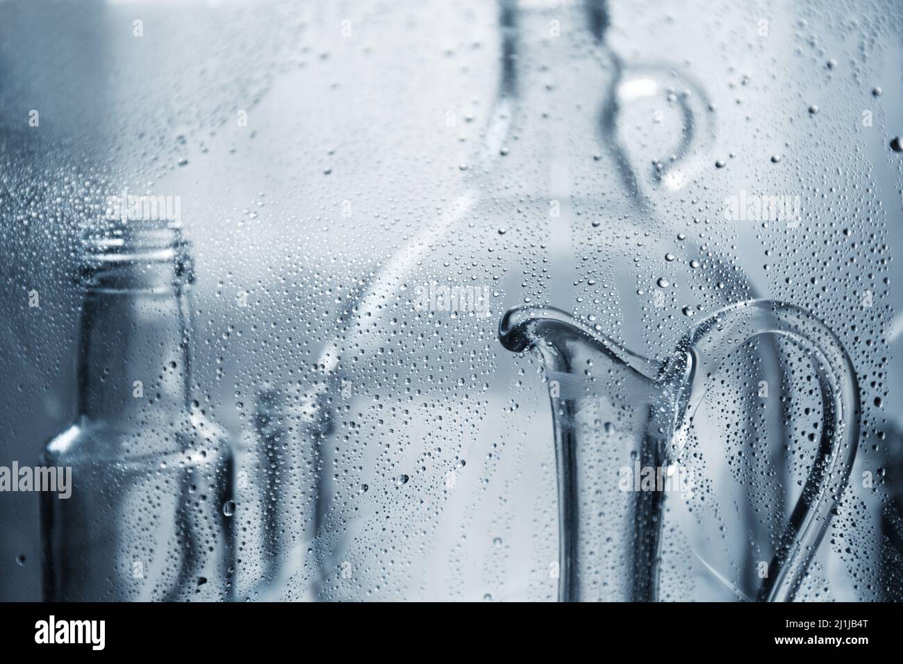 Karaffe für Wasser. Transparente Glasflaschen in Wassertropfen. Glasteller. Stockfoto