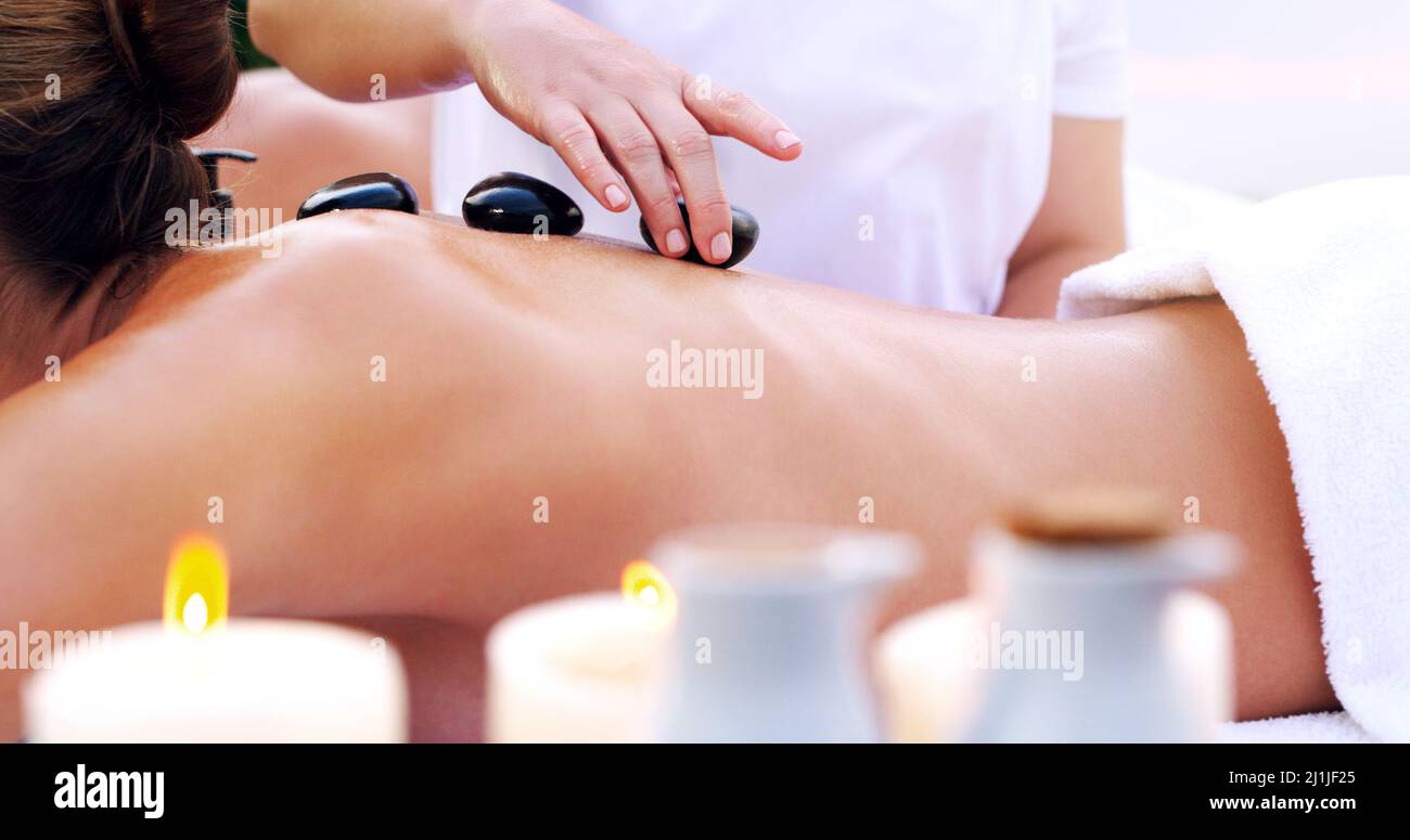 A001 C049 0518YO KOPIE. Aufnahme einer unkenntlichen Frau, die in einem Spa eine Hot Stone Massage bekommt. Stockfoto