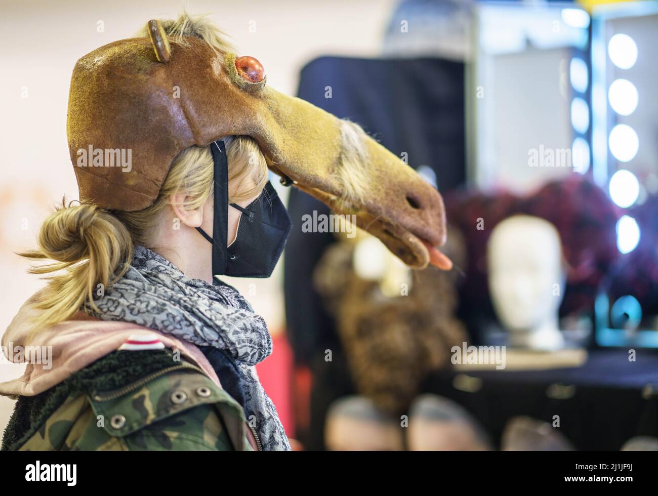 Mainz, Deutschland. 26. März 2022. Ein Kunde probiert eine Pferdemaske aus der Aufführung von 'Ronja Räubertochter' im Trachtenverkauf des Staatstheaters Mainz. Unter den Mainzer Karnevalsliebhabern mit ihrem Bedarf an Kostümteilen ist der Verkauf von Theaterkostümen aus vergangenen Aufführungen, die nicht mehr benötigt werden, sehr beliebt. Kredit: Frank Rumpenhorst/dpa/Alamy Live Nachrichten Stockfoto