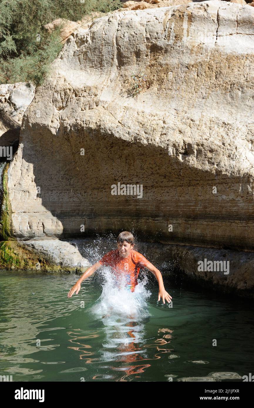 Junge, der von einer Klippe ins Wasser springt Stockfoto