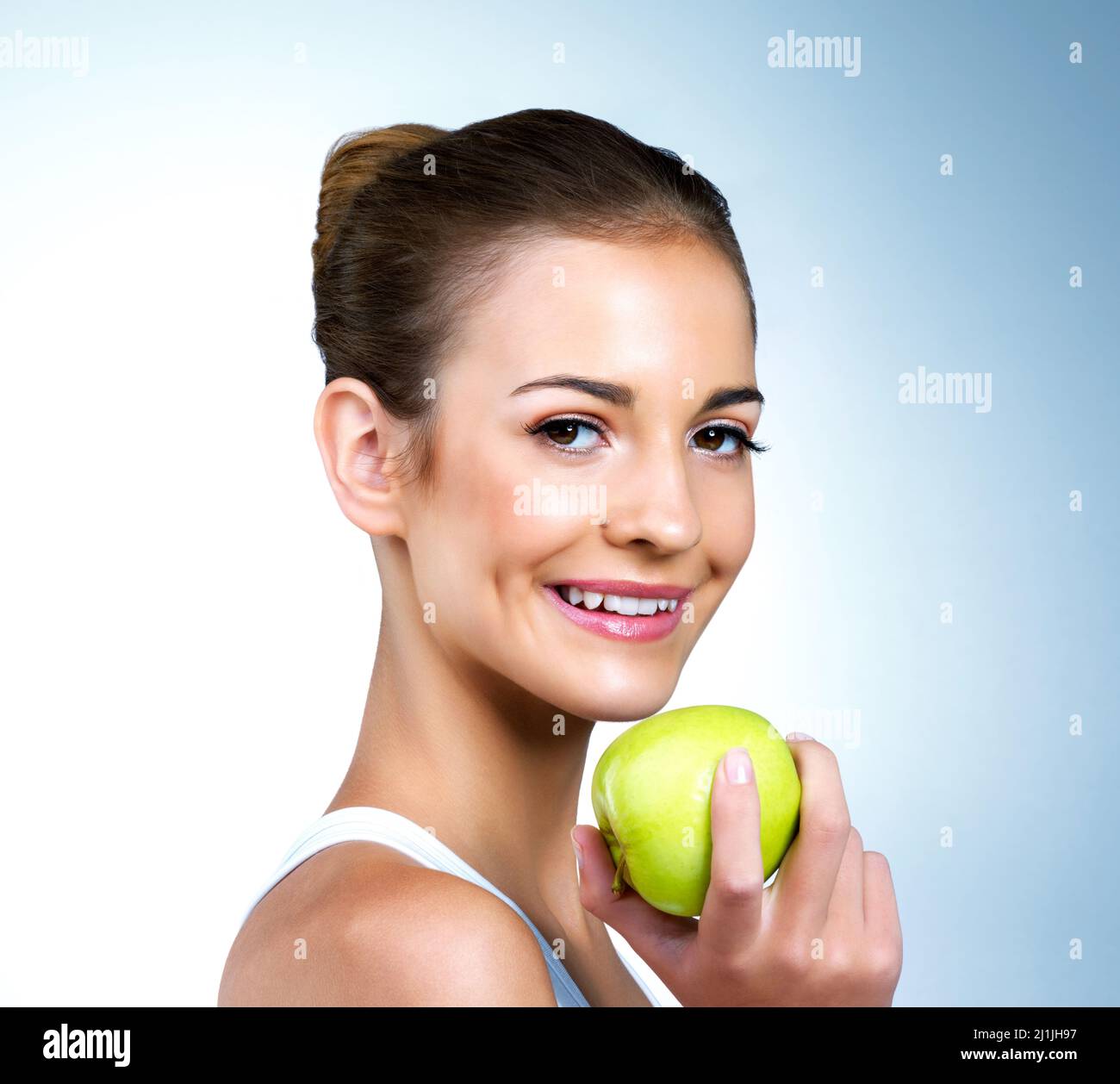 Es ist das Geheimnis meines gesunden Glühen. Porträt einer gesundheitsbewussten jungen Frau, die im Studio mit einem Apfel posiert. Stockfoto