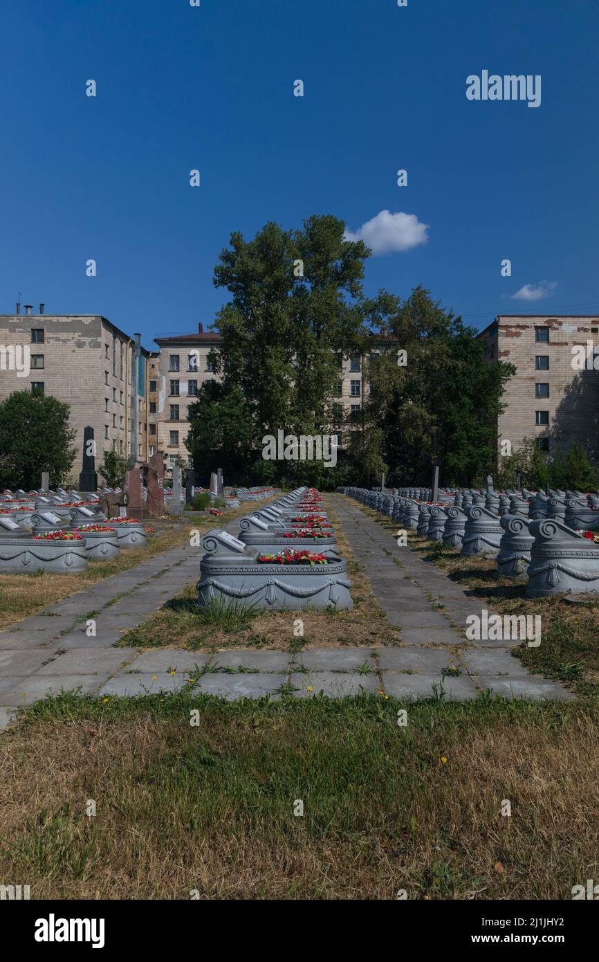 Sankt Petersburg, Russland - 18. Juli 2021: Gräber auf dem Militärfriedhof des Zweiten Weltkriegs vor dem Hintergrund von Wohngebäuden vert Stockfoto