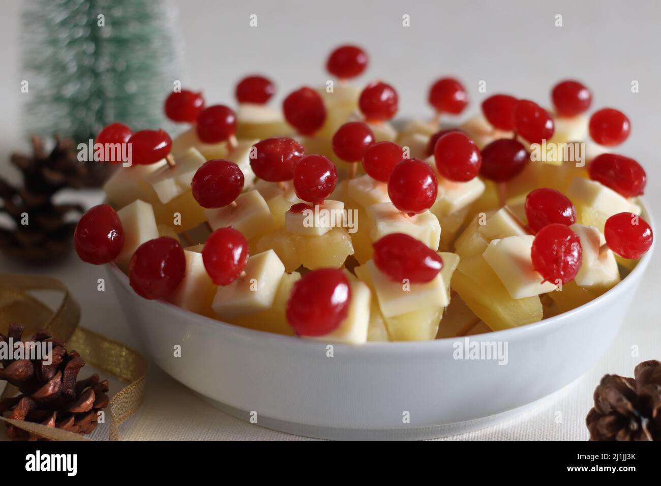 Ananas mit Käsekirsche. Eine leicht zu montierende, kochende Vorspeise. Aufgenommen auf weißem Hintergrund Stockfoto