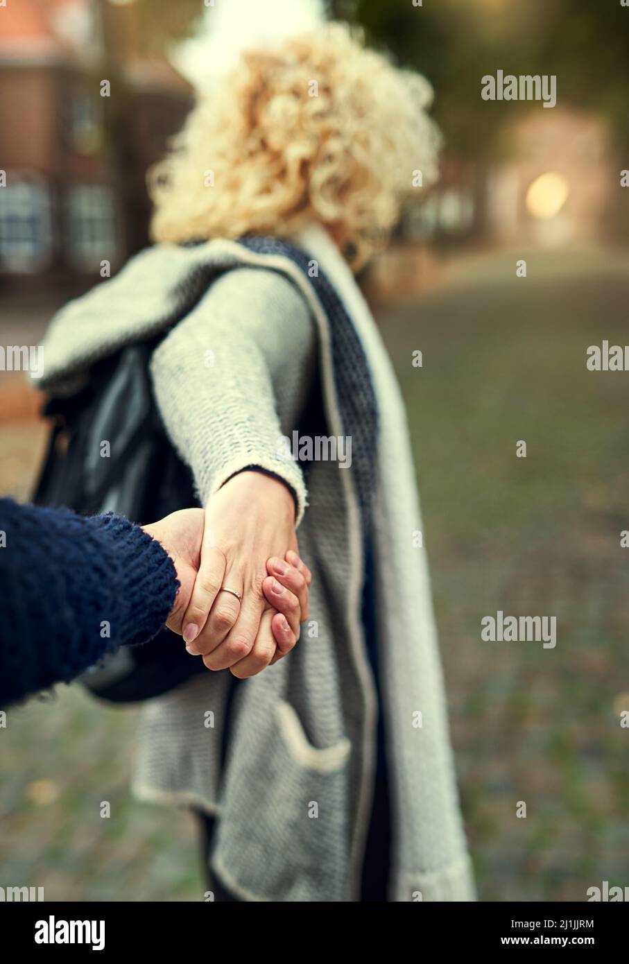Komm schon, liebe. Rückansicht einer jungen Frau, die ihren Mann durch eine fremde Stadt führt. Stockfoto