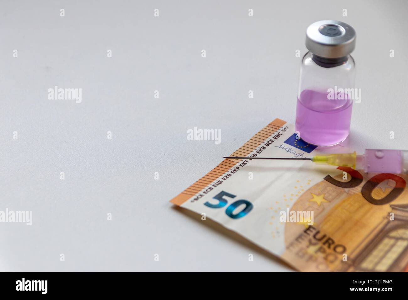 50 Euro Banknote und Injektionsspritze mit rosa medizinischen flüssigen Medizin warten auf einen reichen Patienten, um seine Krankheiten zu heilen, wenn viel Geld für die Gesundheit bezahlt Stockfoto
