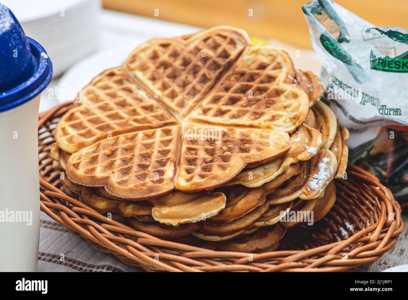 Waffel oder Waffeln in einem Korbkorb, Gericht aus gesäuertem Teig oder Teig, der zwischen zwei gemusterten Tellern gekocht wird Stockfoto