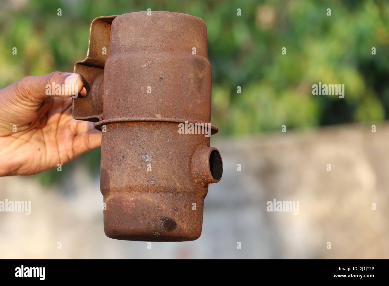 Rostiger Metallkamin eines alten Dieselmotors zur Freisetzung von Verbrennungsgasen, die auf natürlichem Hintergrund in der Hand gehalten werden Stockfoto