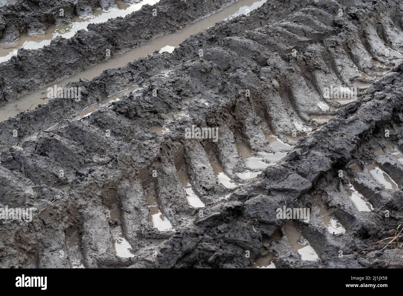 Spuren von Reifen im Schlamm, ländliche schlammige Straße Detail, weniger gereist Stockfoto