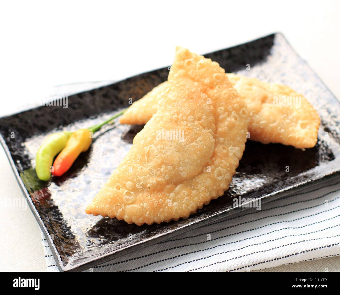 Kue Pastel oder Jalangkote, beliebtes Gericht aus Südostasien als Curry-Puff. Dieser Snack mit Reisnudeln, Karotten, Kartoffeln gefüllt und mit Gree serviert Stockfoto