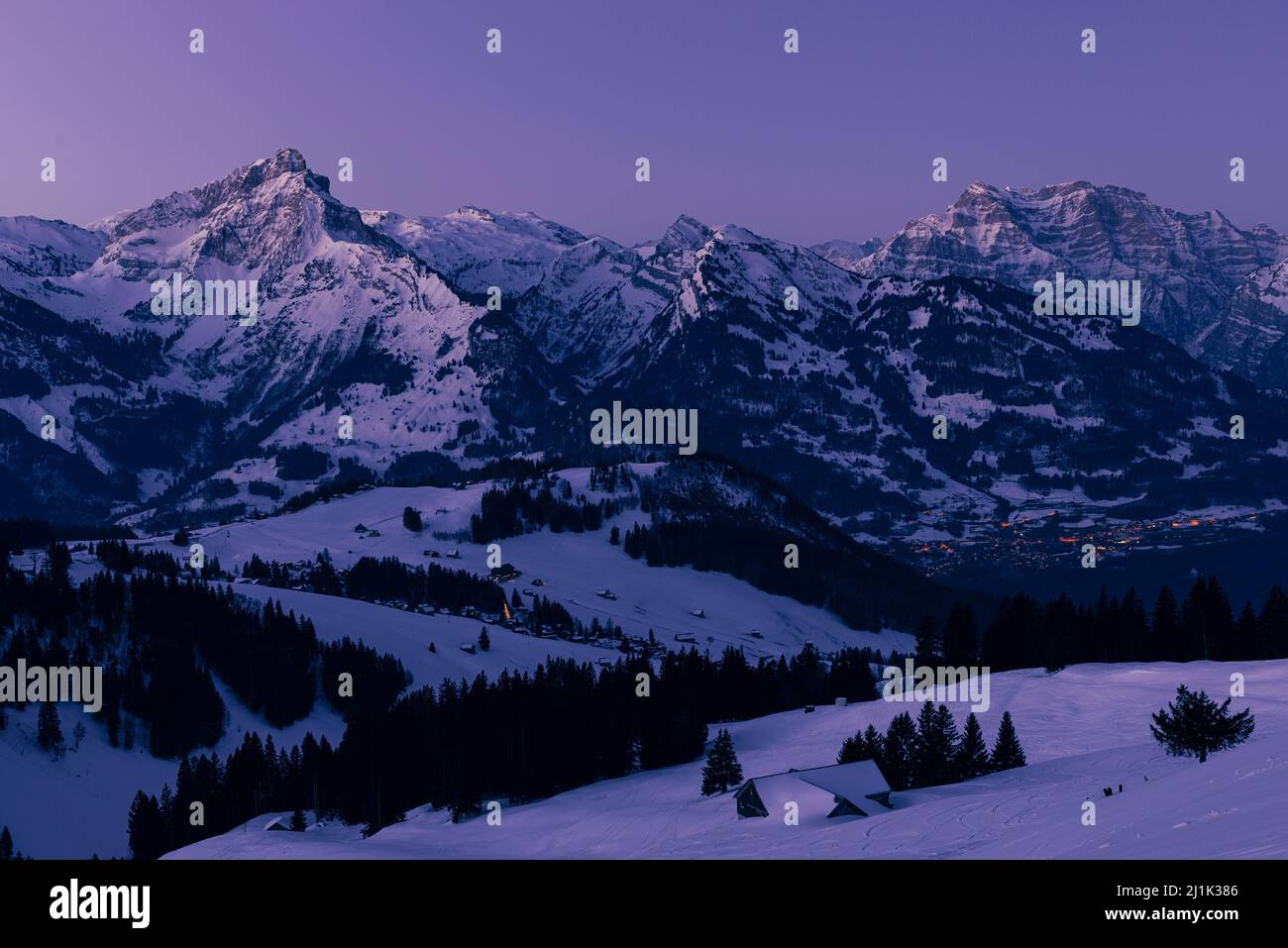 Im Winter leuchten die schneebedeckten Berggipfel der Glarner Alpen in der Schweiz bei Sonnenaufgang Stockfoto