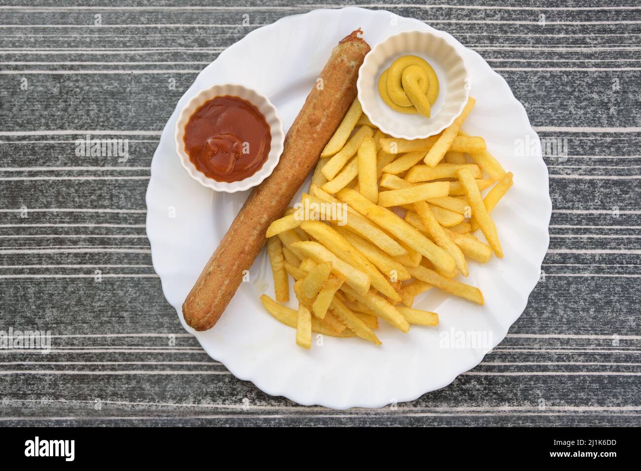 Gegrillte Wurst oder deutsche Bratwurst und Pommes frites mit Ketchup und Senf auf einem Teller, ungesunde Fast Food, aus der Sicht von oben, ausgewählte fo Stockfoto