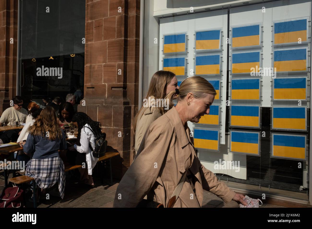 Glasgow, Großbritannien. 26.. März 2022. Das Immobilienmakler-Fenster zeigt die blaue und gelbe ukrainische Flagge anstelle von Immobilienauflistungen, zur Unterstützung der Ukraine in ihrem aktuellen Krieg mit Präsident PutinÕs Russia, in der Merchant City-Gegend von Glasgow, Großbritannien. 26. März 2022. Foto: Jeremy Sutton-Hibbert/ Alamy Live News. Stockfoto